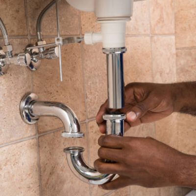 Close-up Of Male Plumber's Hand Fixing Sink In Bathroom